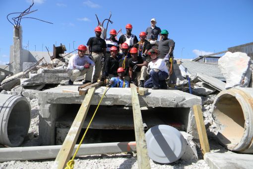 Emergency Management student atop the rubble pile