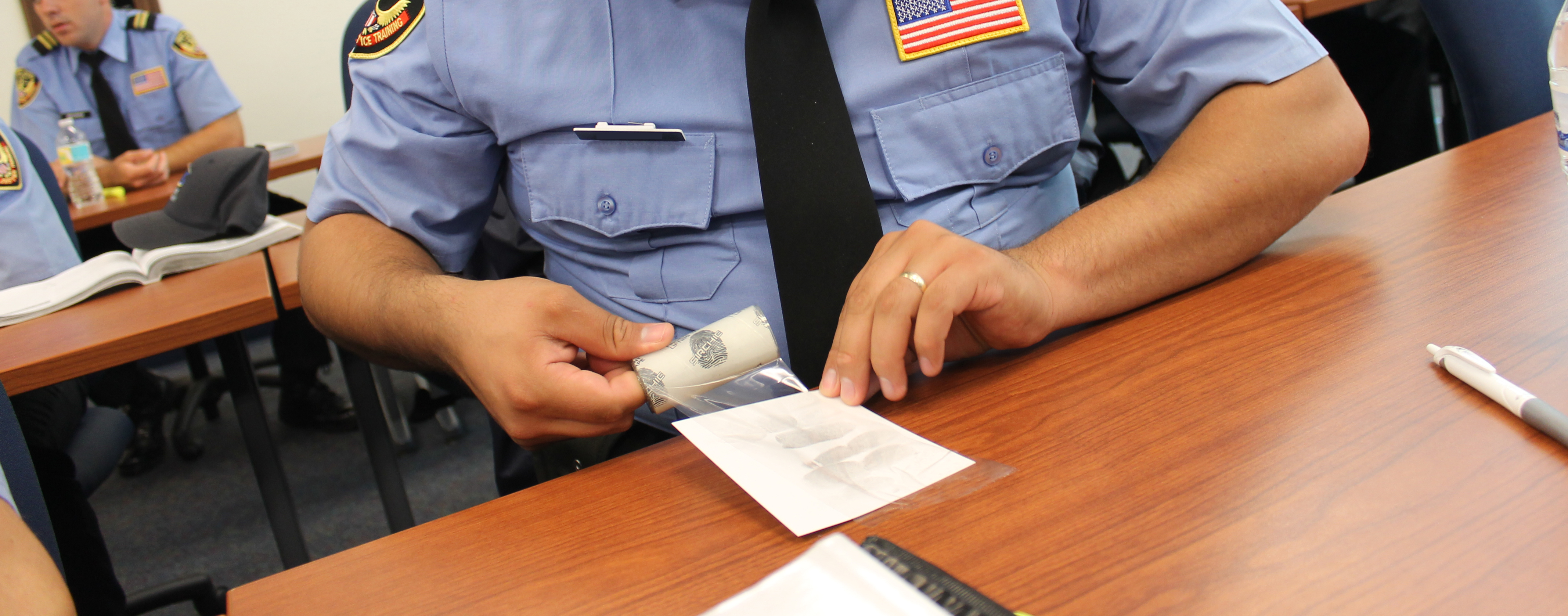 Law enforcement student learning to take finger print